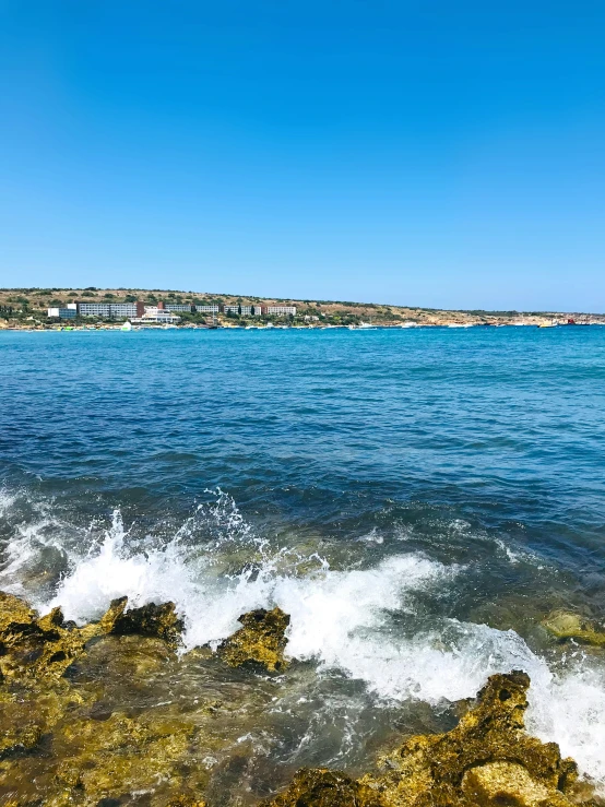 a body of water with the shore in the background