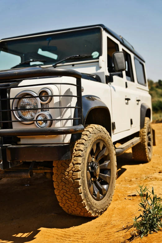 the front bumper of a white jeep in the desert