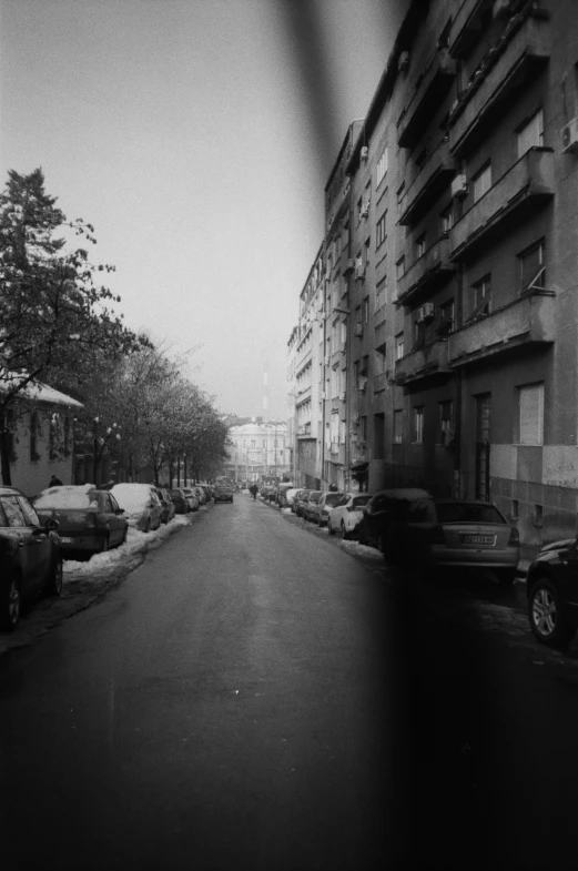 the road is empty and full of cars in front of buildings