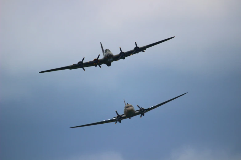 two planes are flying close together under the sky