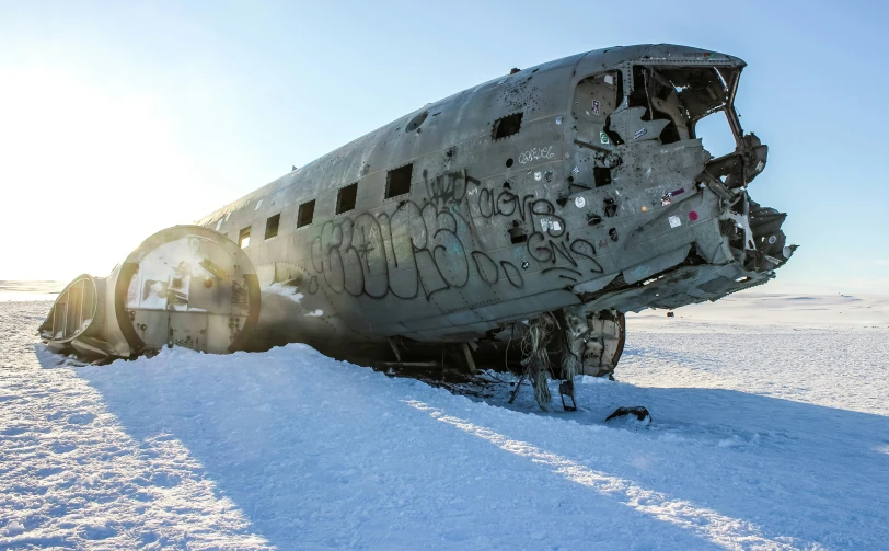 an airplane covered in snow on top of a hill