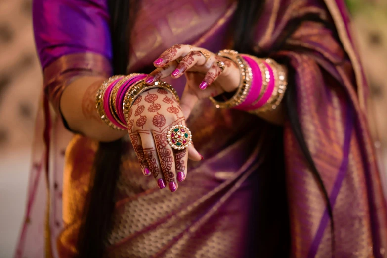 woman wearing pink and purple sari and holding a henyard