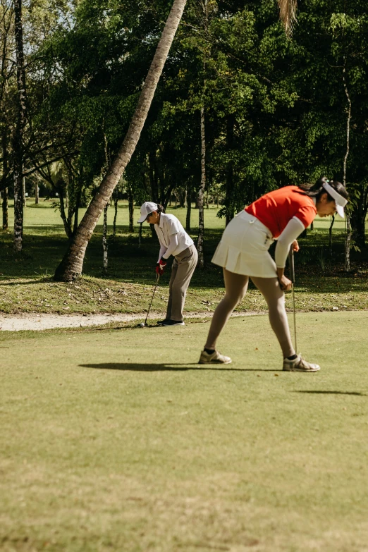 two men playing golf on a nice green