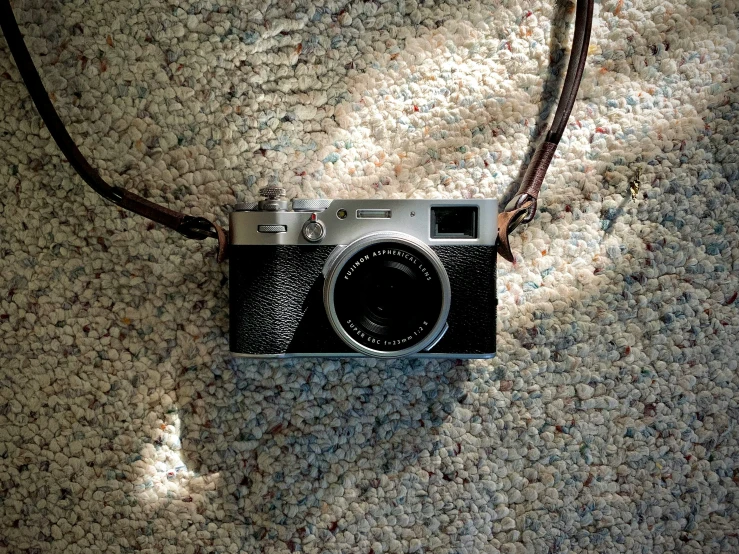 a camera with a cord is laying on a carpet