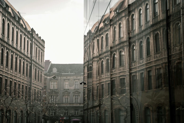 an old street with multiple large buildings and a person with an umbrella