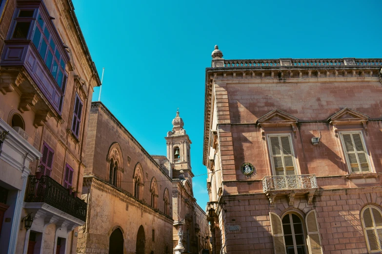 an old building on a street with a clock tower in the background