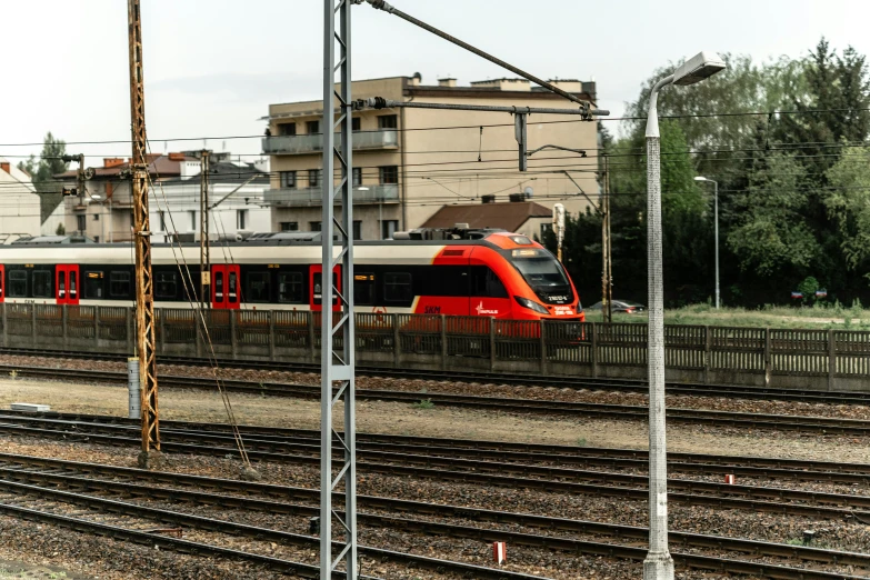 a train traveling past a large brown building on tracks