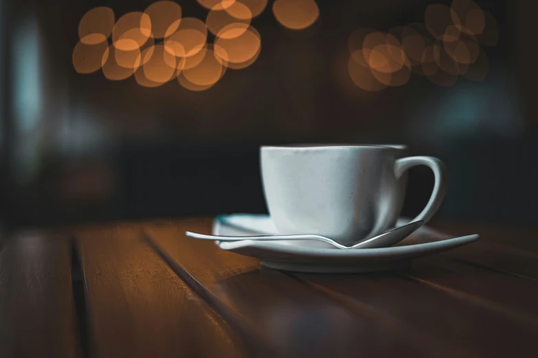 a coffee cup with saucer is set on the table