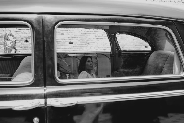 a car with its door window open as another woman sits in it