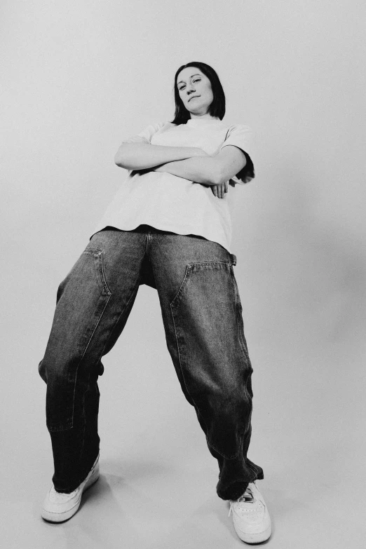 black and white po of a woman standing with her arms crossed