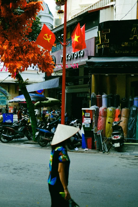 there is a person walking down the street with an asian hat