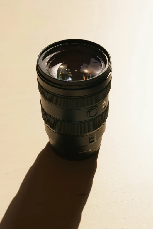 an empty lens sits on a table and casts a shadow