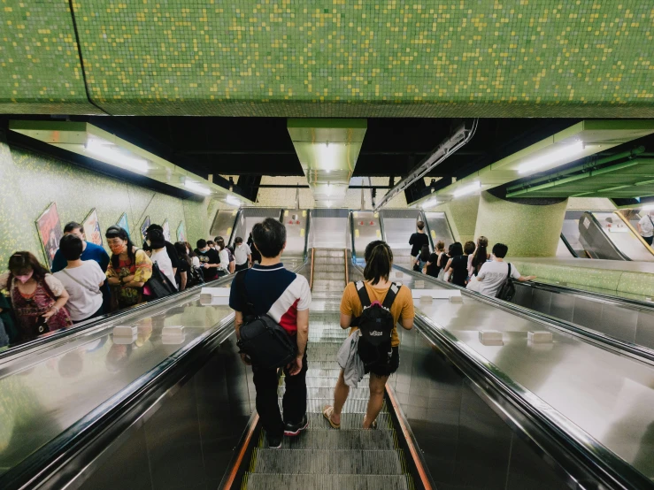 people are riding an escalator inside the station