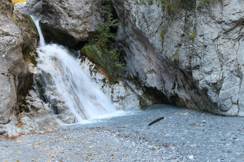 water running out of a cave into a river