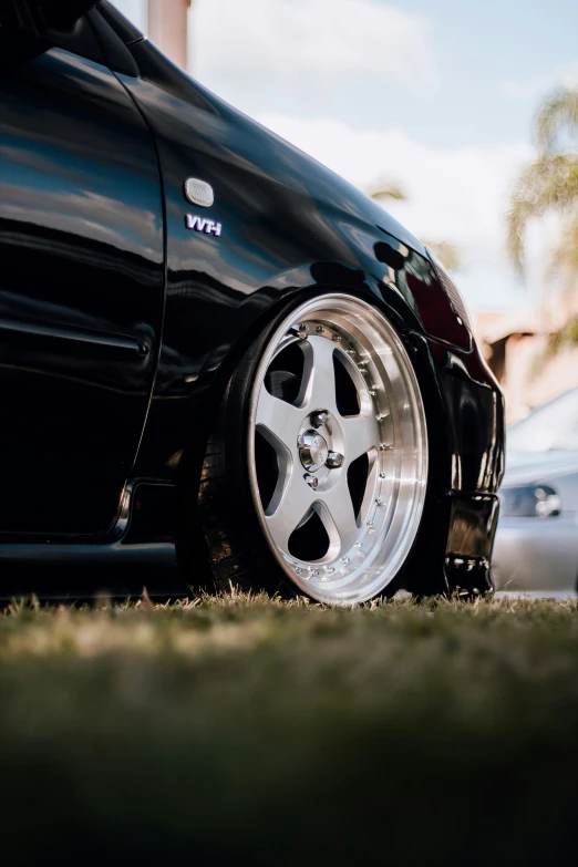 there is a very black sports car parked on the side of the street