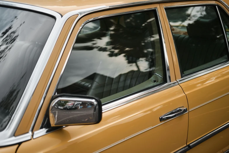 an orange classic car has a rear door mirror on it