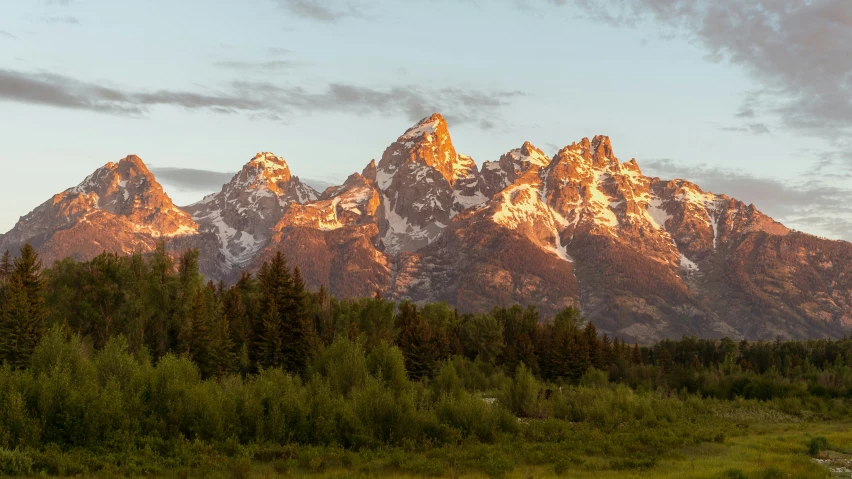 the mountains covered with trees are shown in the setting sun