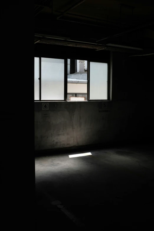 an empty room with dark floor and windows