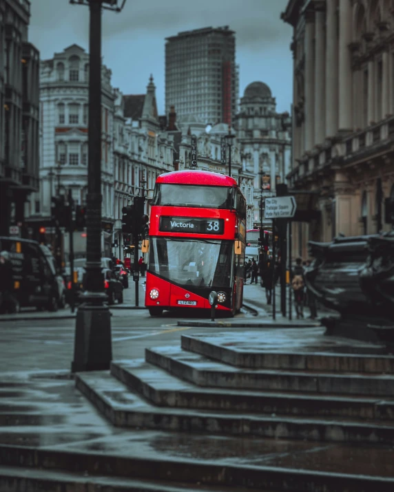 the double decker bus is driving down the street