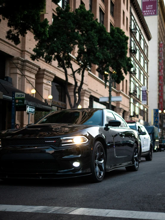 some very pretty cars in a street by a building