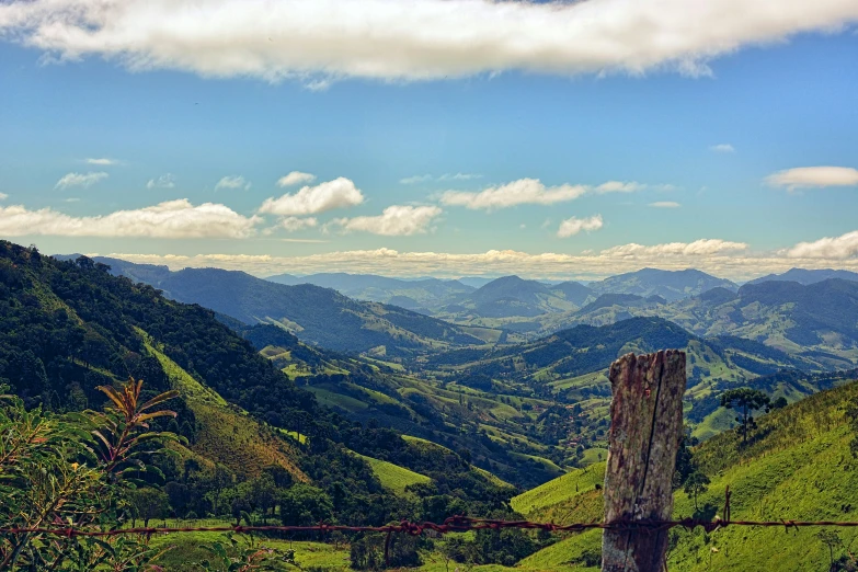 a view of the mountains from a grassy hill side