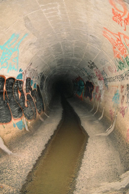 there is graffiti on the wall of this tunnel