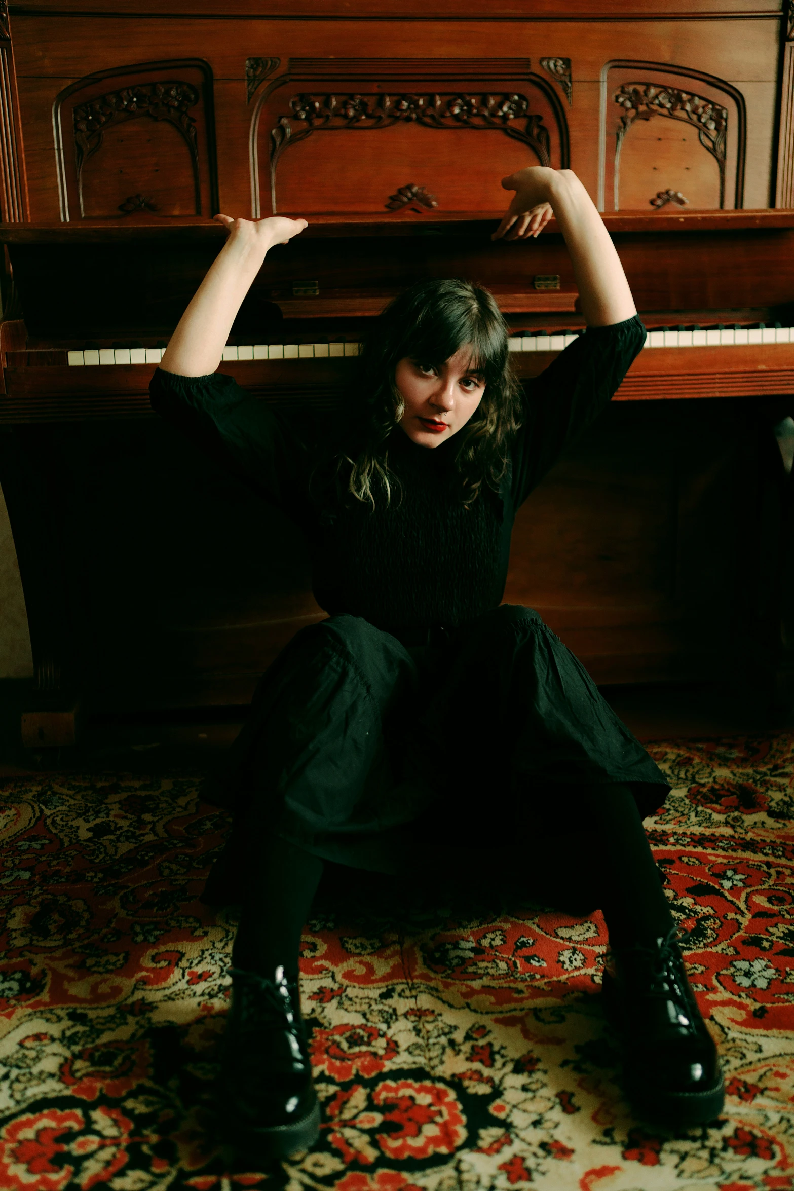 a girl sitting at a piano and stretching her arm