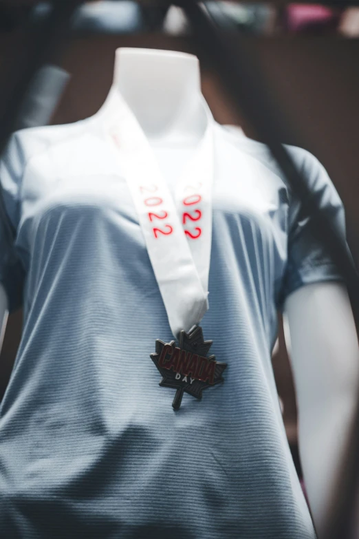 a women's shirt and medal displayed on a mannequin