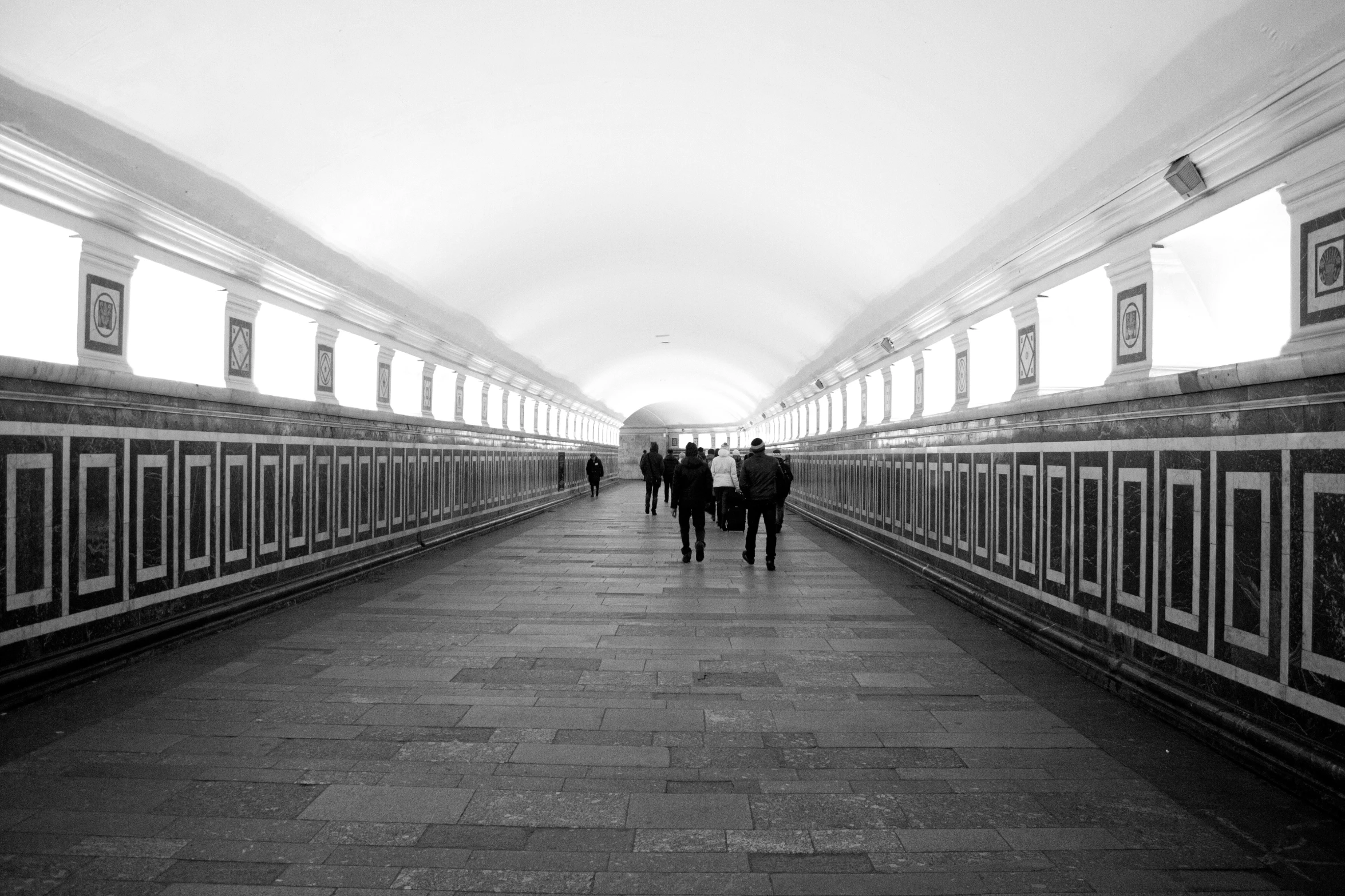 people are walking on the subway platform and it's foggy