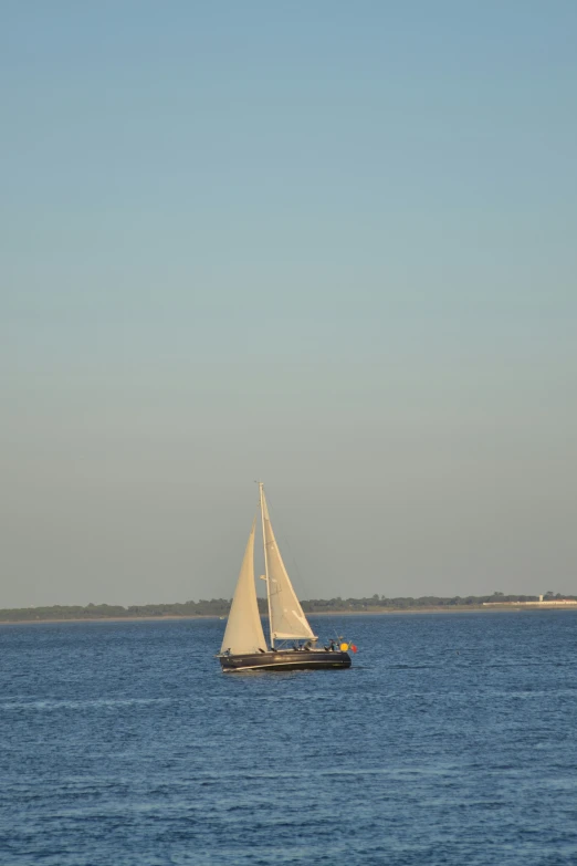 a sail boat sailing across a body of water