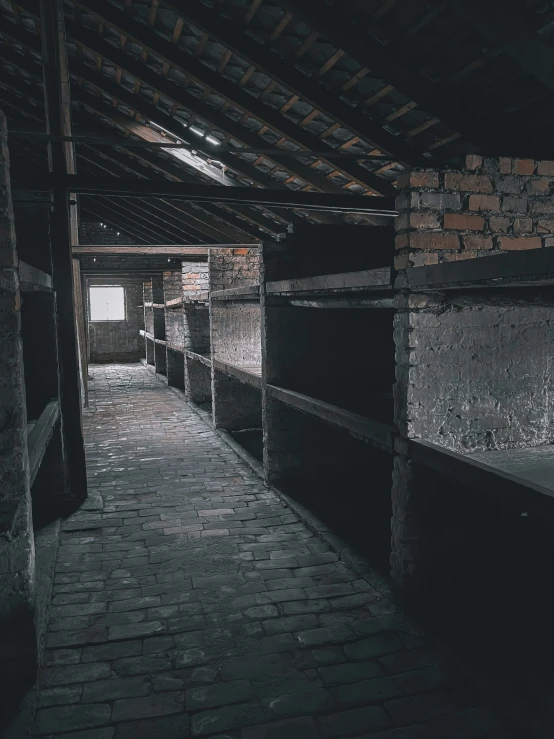 an empty hallway in a dark building with a brick wall