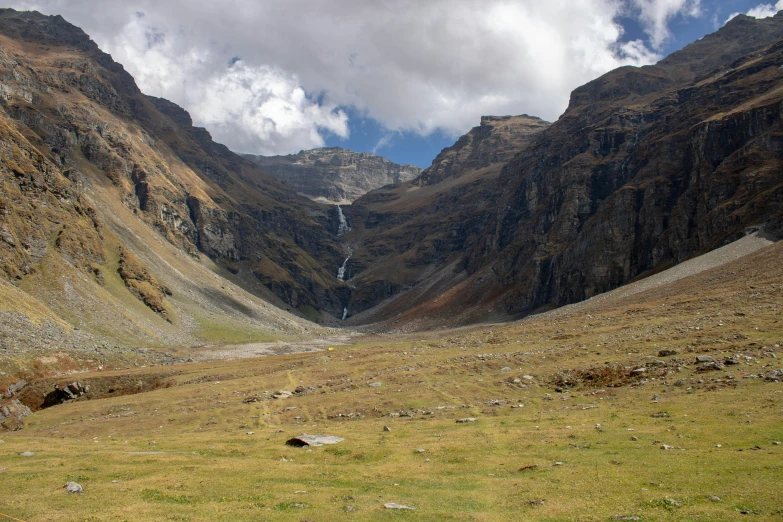 a mountain and grassy area with hills in the distance