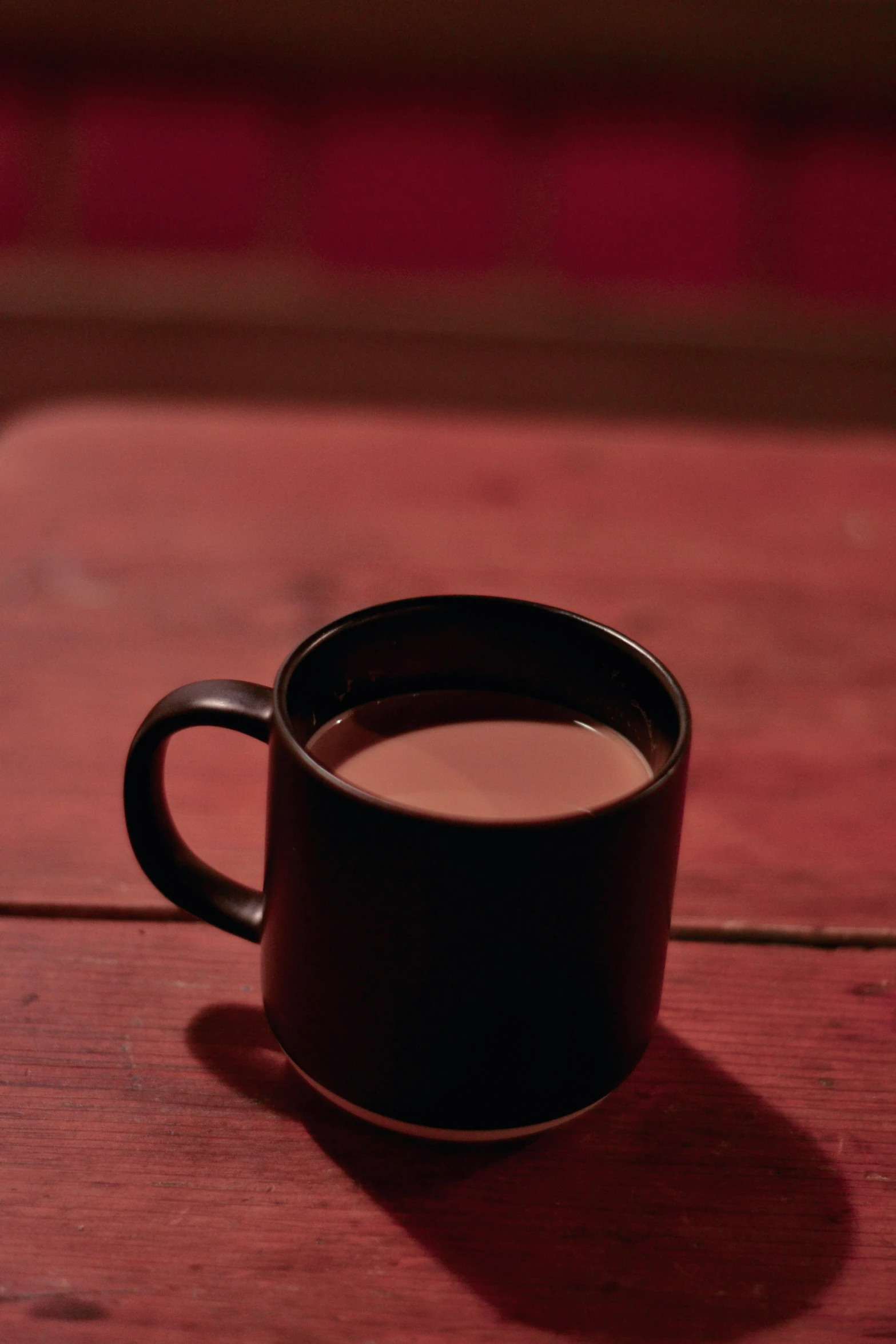 a mug sitting on a table with a small piece of cloth next to it