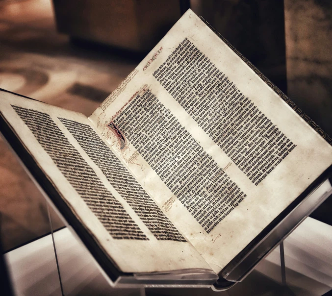 an old book is sitting on a stand