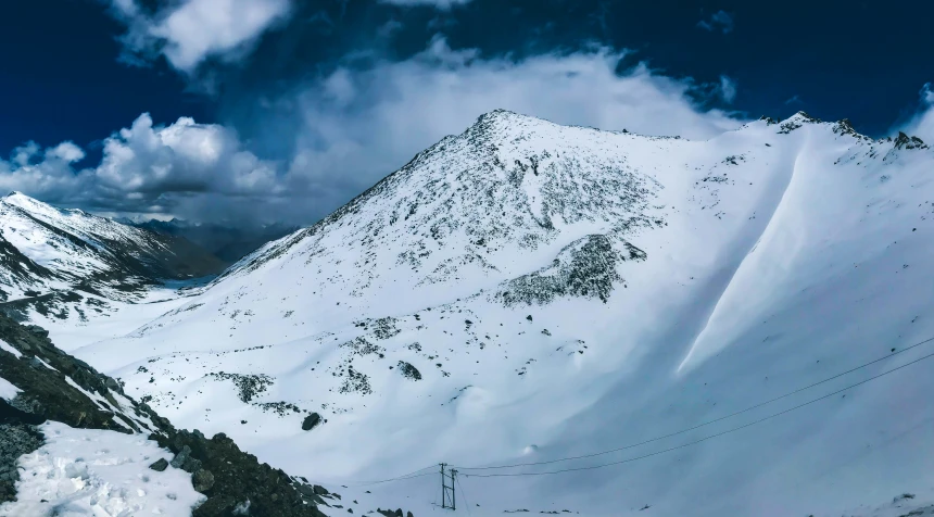 a view looking up at a ski lift on a snowy mountain