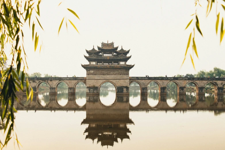 an old bridge spanning a river with some arches in the middle