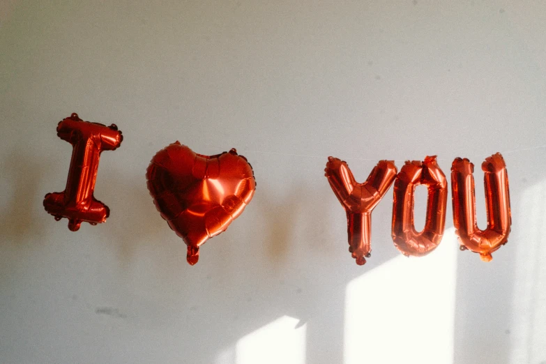 some foil balloons are lined up to spell out love