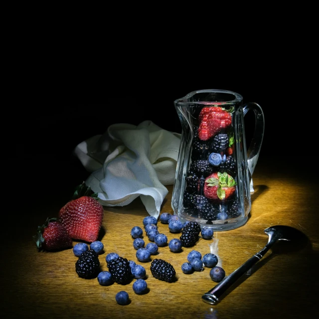 berries in a container, an old pair of shears and a bottle on a table