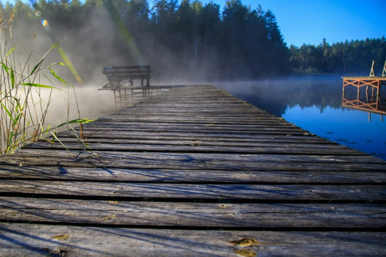 there is a dock and a bench on the water