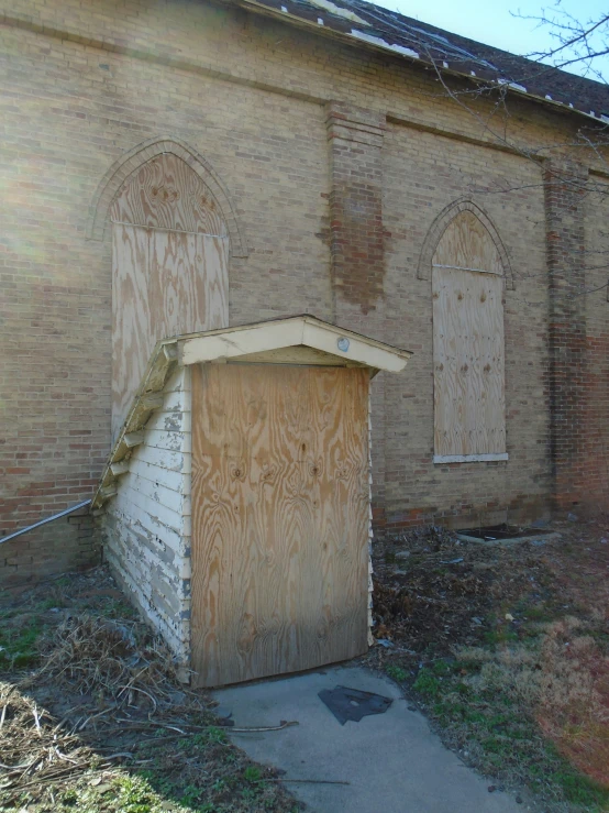 an old building with wooden doors sitting in front of it