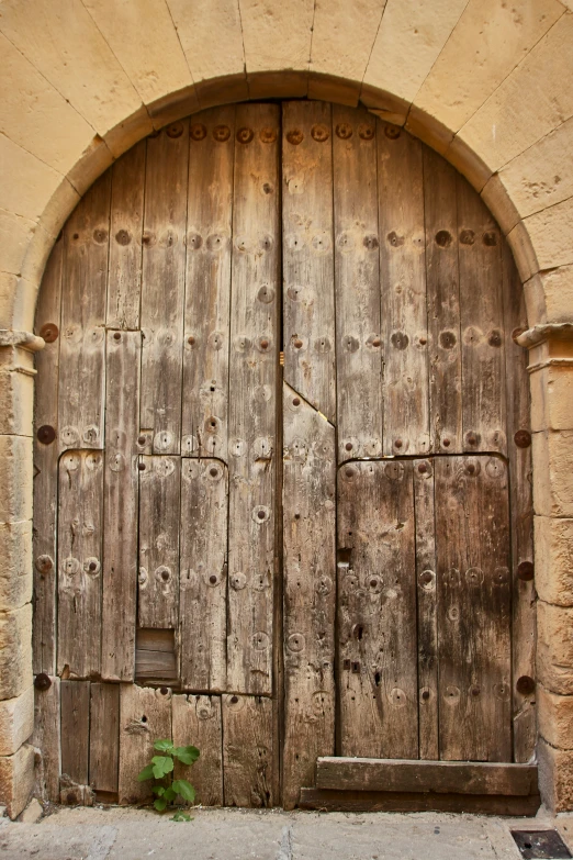 an old wooden door is open to a courtyard