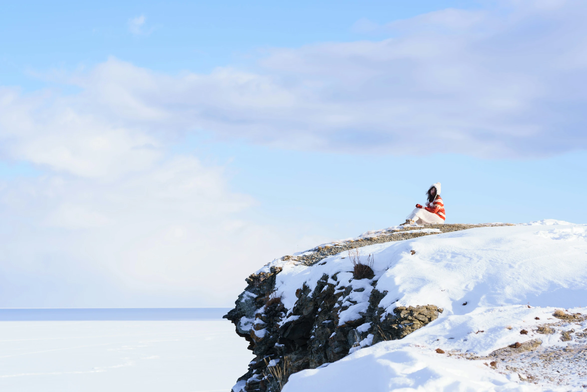 people on a snowy hill with blue skies in the background