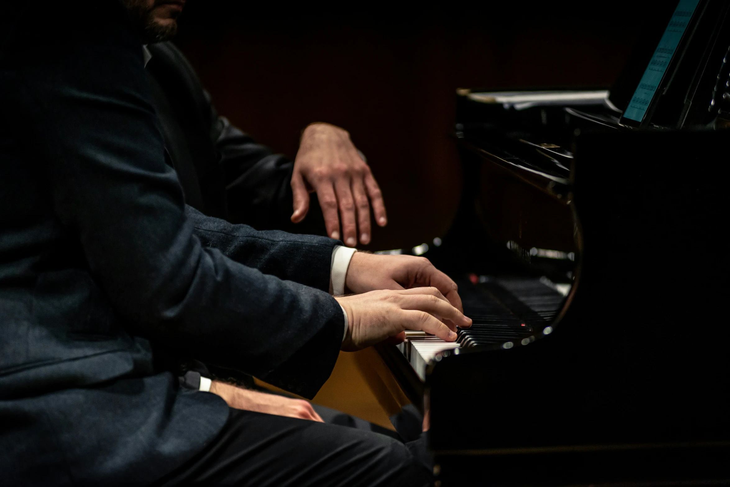 the couple of people are playing a piano together