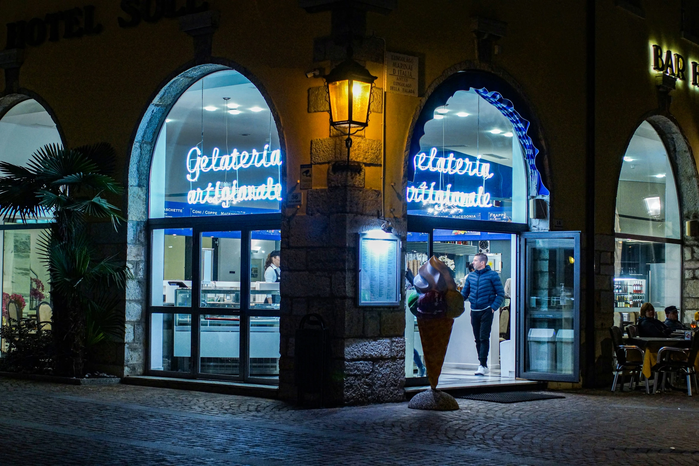 a couple walking away from a restaurant on a night