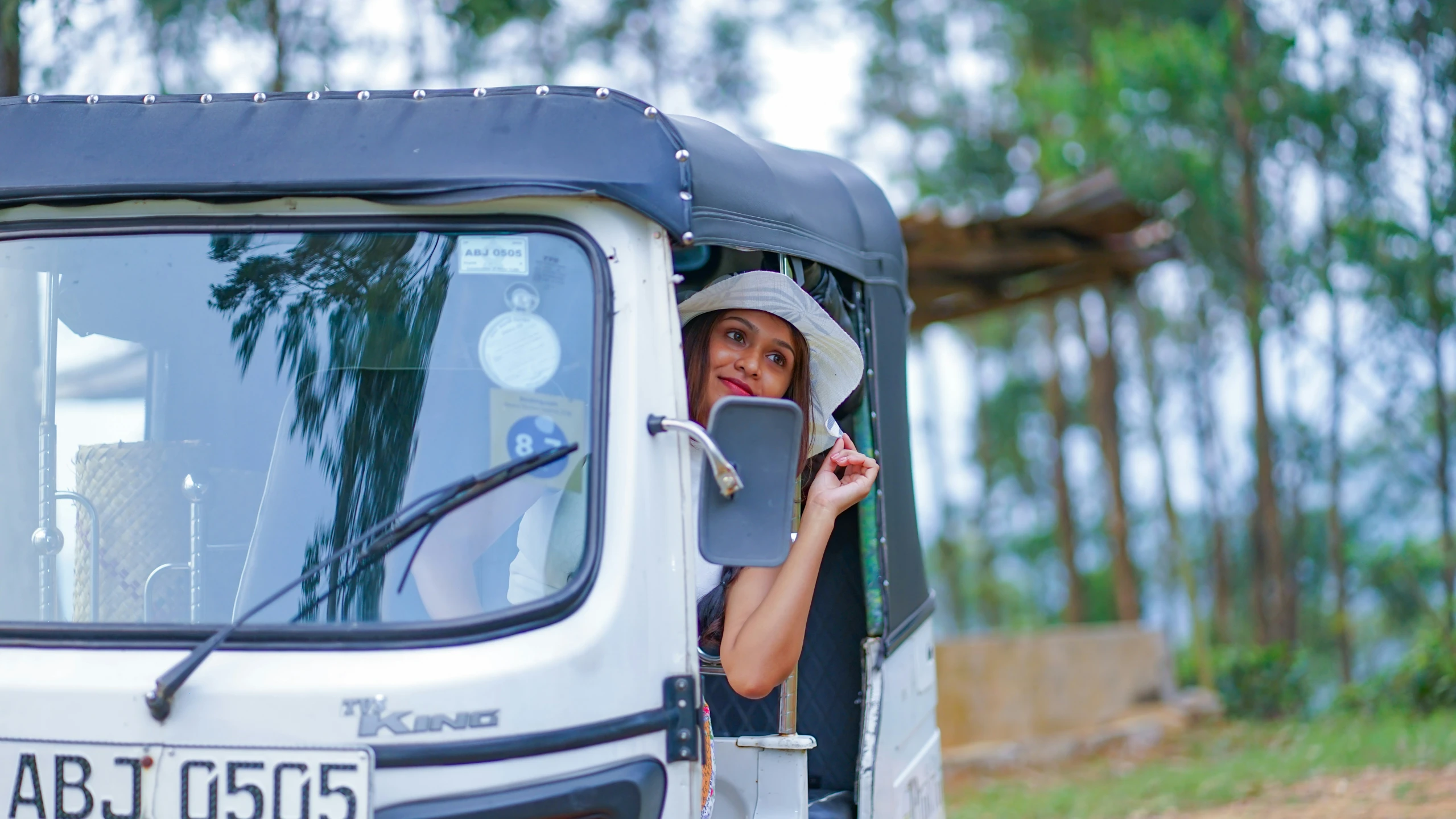 a woman in a white hat and glasses driving a truck