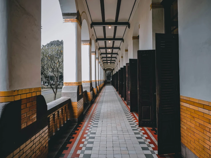 the hallway of an old building with yellow tiles