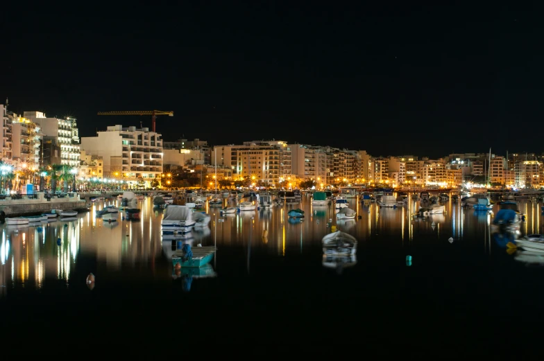boats in the water near the city at night