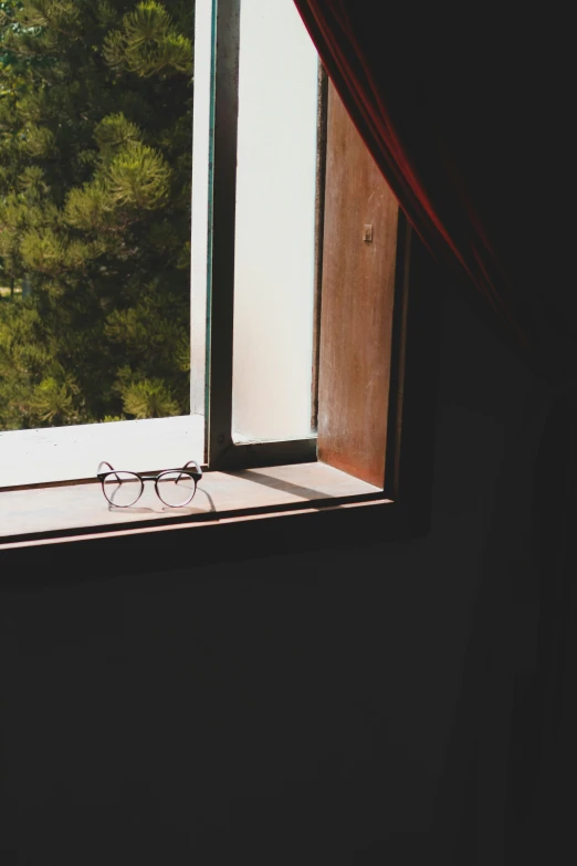 a pair of eye glasses sitting on the windowsill