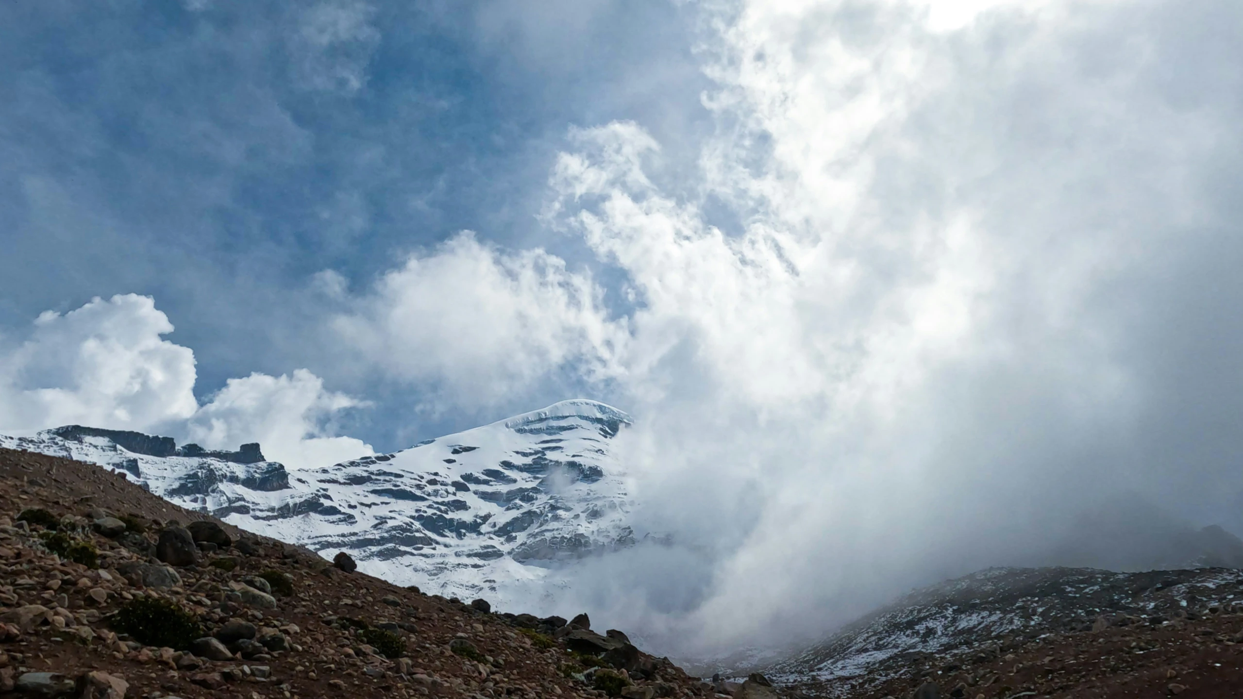 a large snowy mountain with a few clouds