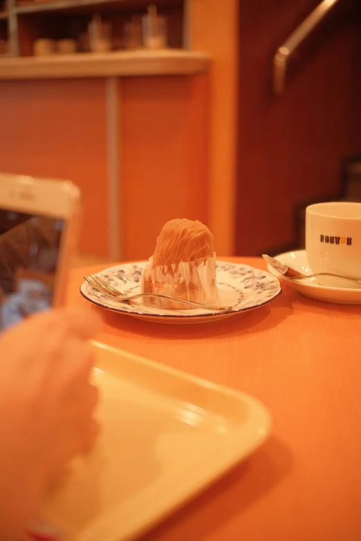 a table topped with plates of food next to cup and phone